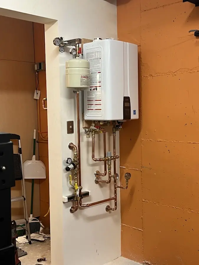 Plumbing technician inspecting water heater connections in Unity